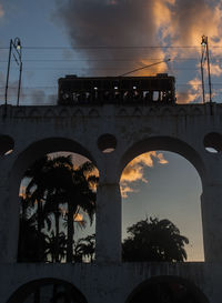 Low angle view of bridge against sky at sunset