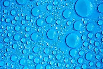 Close-up of water drops on blue surface