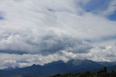 Scenic view of mountains against cloudy sky