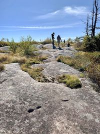 Rear view of people on land against sky