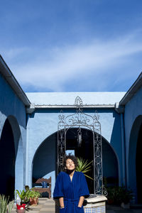 Woman posing in robe outdoors in a countryside house.