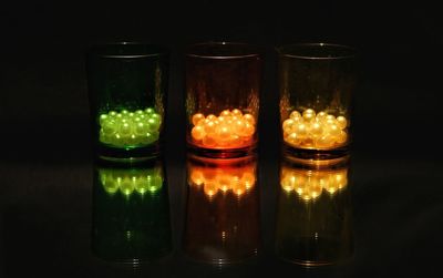 Close-up of illuminated tea light candles against black background