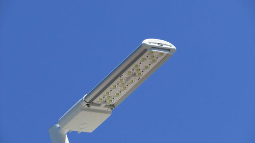 Low angle view of modern street light against clear blue sky