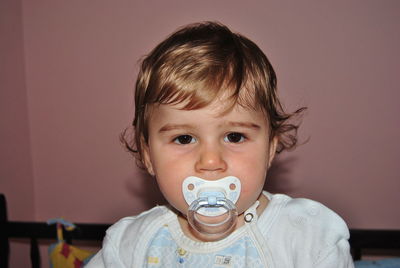 Portrait of baby boy sucking pacifier at home