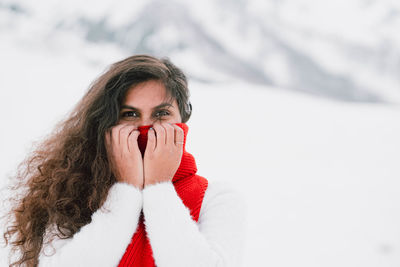 Portrait of young woman standing on snow