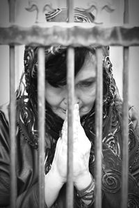 Woman praying seen through fence