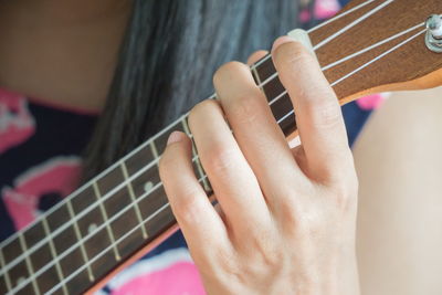 Cropped hand playing guitar at home