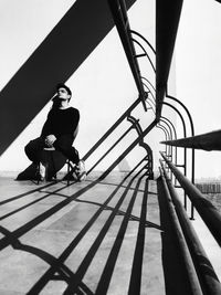 Full length of woman sitting on railing