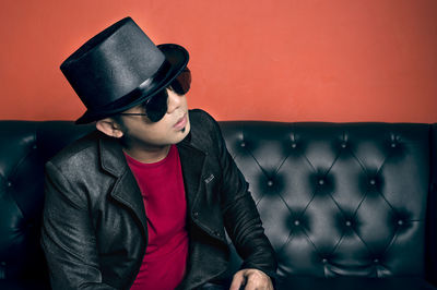 Young man wearing blazer sitting on sofa