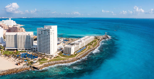 Luxury hotel with infinity pool and palms all around it.