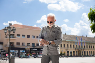 Man standing in city against sky