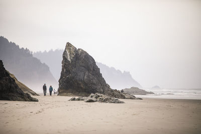 Retired couple take a long walk on oregon coast beach.