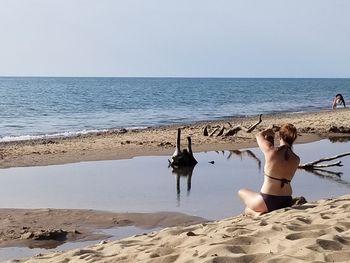 Full length of woman on beach against clear sky