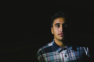 Portrait of man against black background