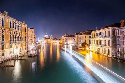 Canal passing through city buildings at night