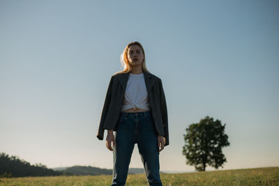 Portrait of woman standing on field against sky