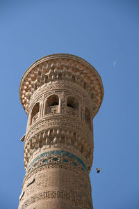 Low angle view of kalyan minaret against clear blue sky