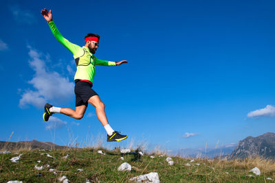 Full length of man jumping against sky
