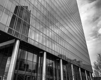 Low angle view of glass building against sky