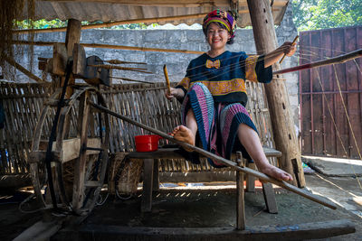 Full length portrait of boy sitting on ladder