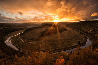 Scenic view of dramatic sky over landscape during sunset