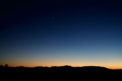 Scenic view of silhouette moon against sky at sunset