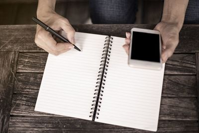 Midsection of man reading book on table