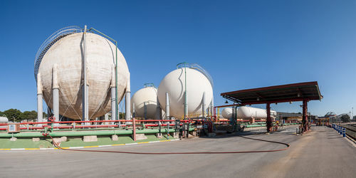 Panoramic view of factory against clear blue sky