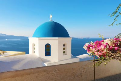 Scenic view of sea by building against blue sky