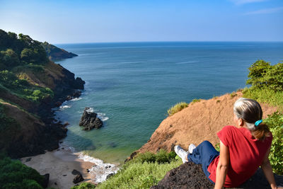 Rear view of woman looking at sea against sky