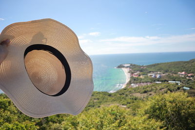 Close-up of hat on beach against sky