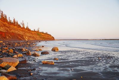 Rocks on shore against clear sky