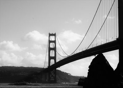 Low angle view of bridge against cloudy sky