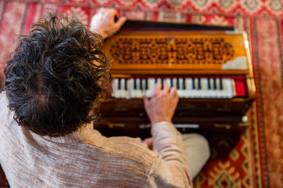 High angle view of man playing harmonium