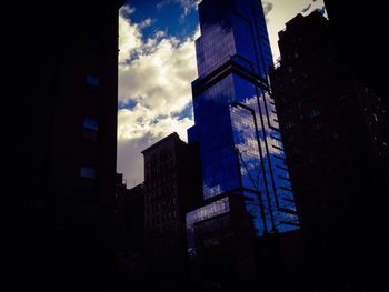 Low angle view of buildings against cloudy sky