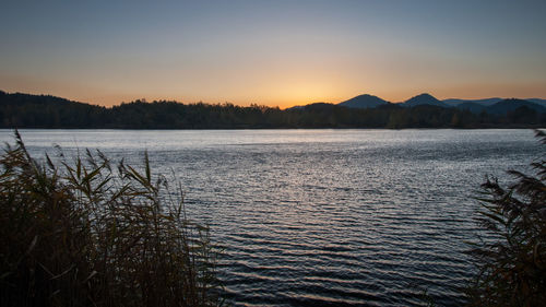 Scenic view of lake against sky during sunset