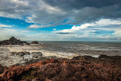 Rocky sea beach with crashing waves at morning from flat angle