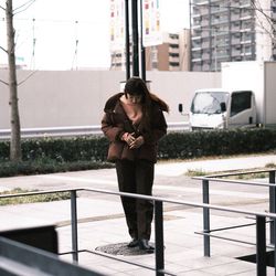 Woman photographing with camera in city