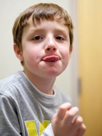 Close-up portrait of boy sticking out tongue