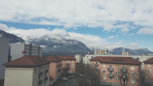 Houses by mountain against sky