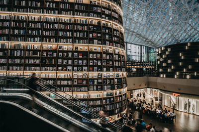 People on street by modern buildings in city