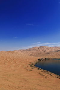 Scenic view of desert against blue sky