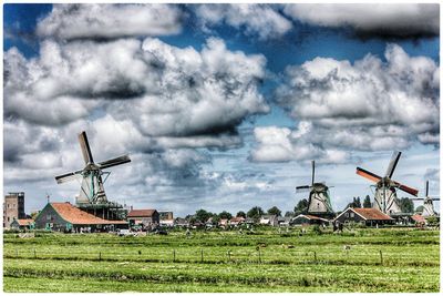 Traditional windmill on field against sky