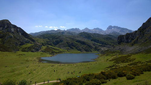 Scenic view of lake and mountains against blue sky