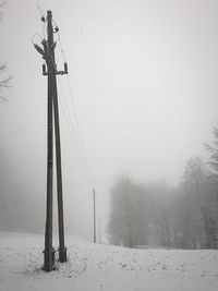 Snow covered field against sky during winter