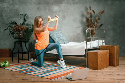  the young woman doing a workout with sport fitness rubber band in for sports at home.