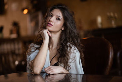 Portrait of beautiful woman sitting on table