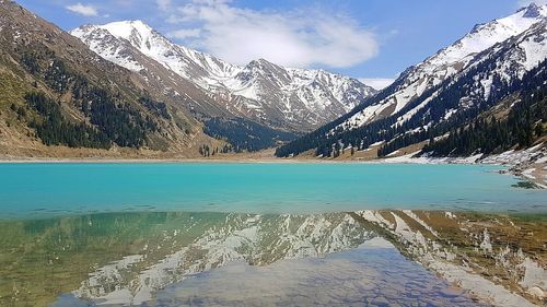 Scenic view of lake and snowcapped mountains during winter