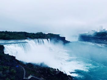 Scenic view of waterfall against sky