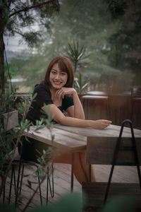 Portrait of young woman sitting on table